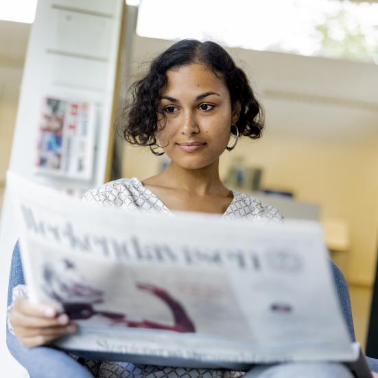 Kvinde læser avis