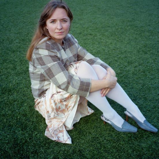 Forfatter Christine Kærulv sidder på græsplæne