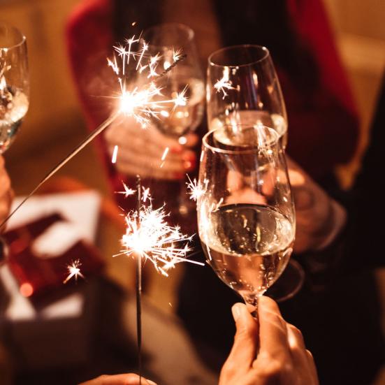 Folk skåler nytåret ind med champagne.