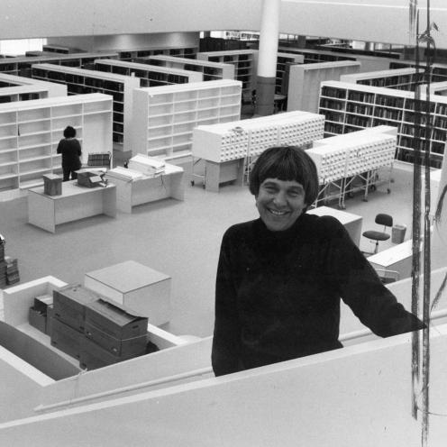 Bibliotekar Aase Bjerre står på trappen op til 1. sal