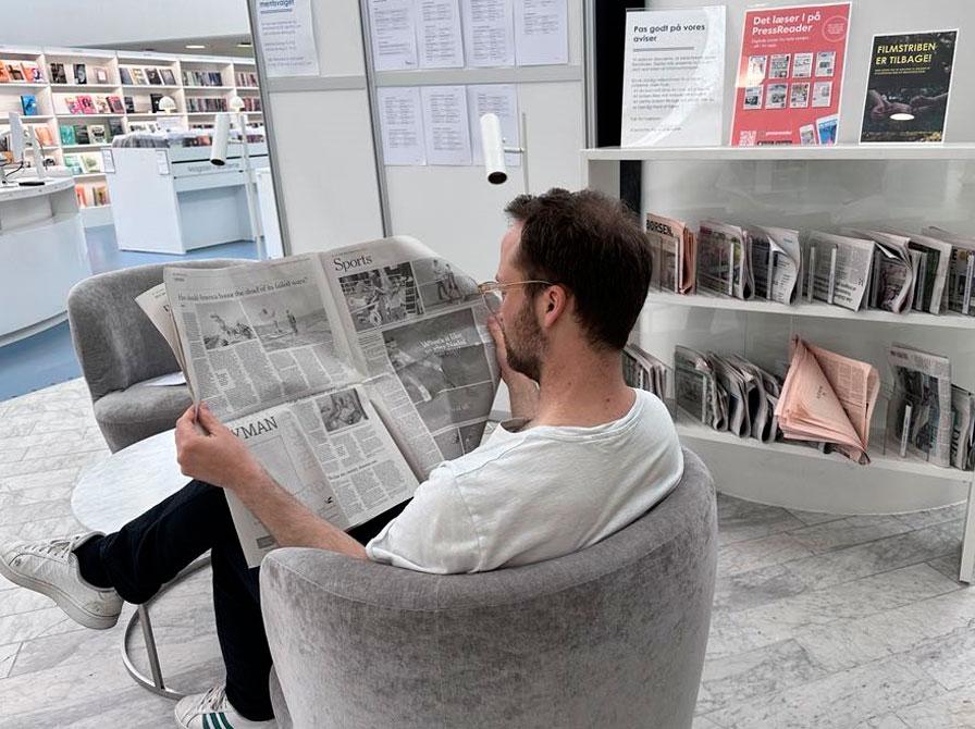 Mand læser avis på Hovedbiblioteket